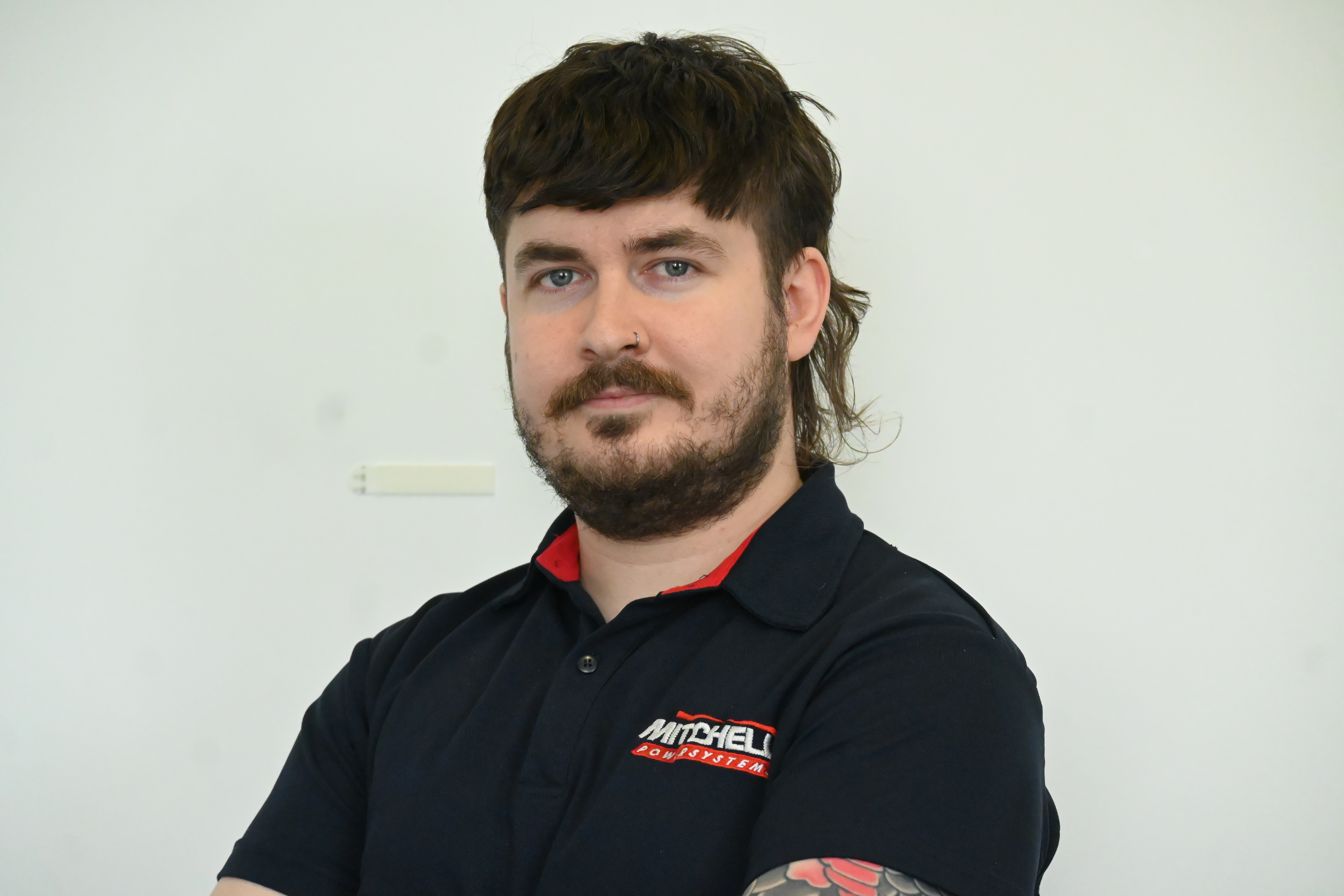 smiling man in blue mitchell powersystems branded polo