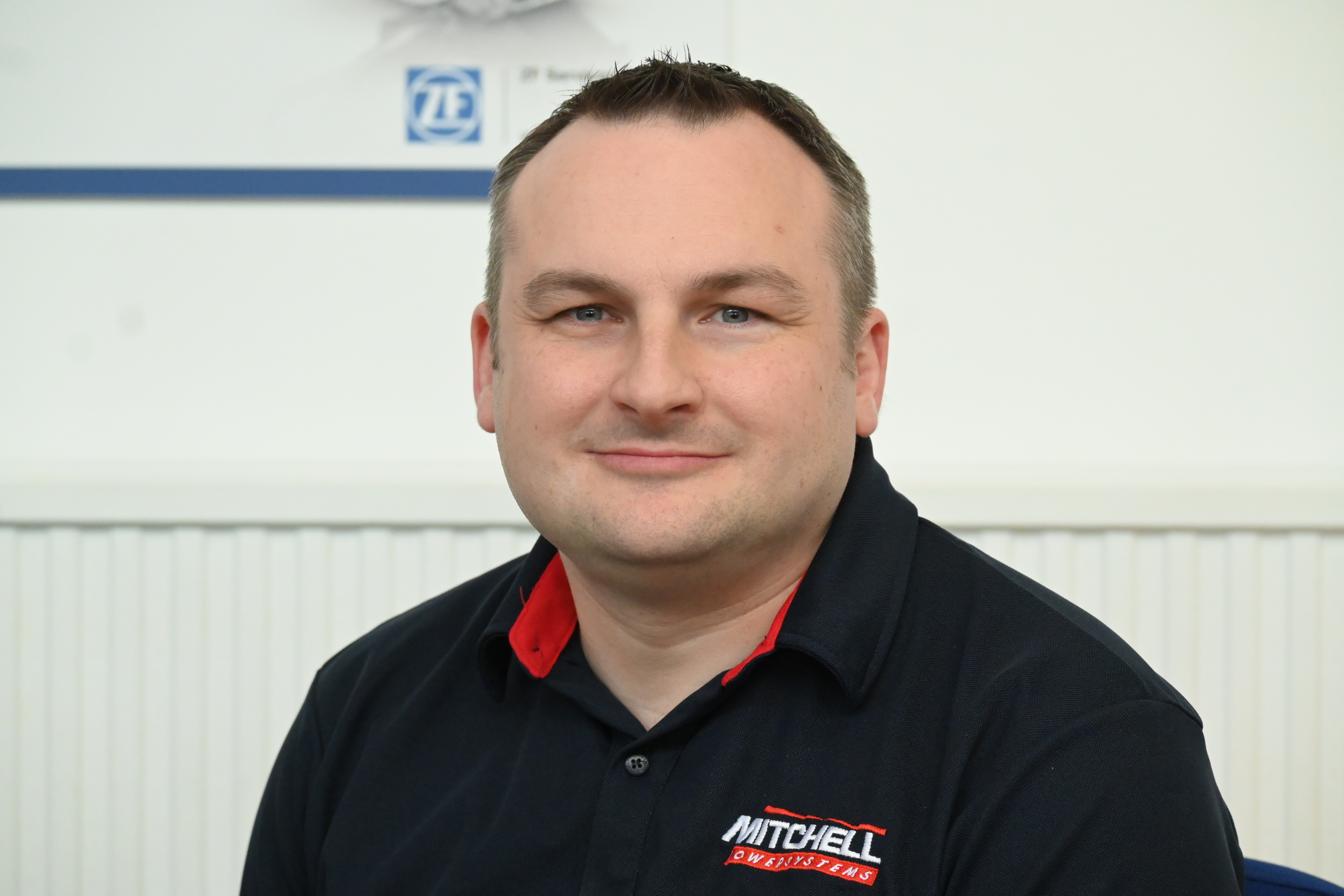 smiliing man in mitchell powersystems uniform