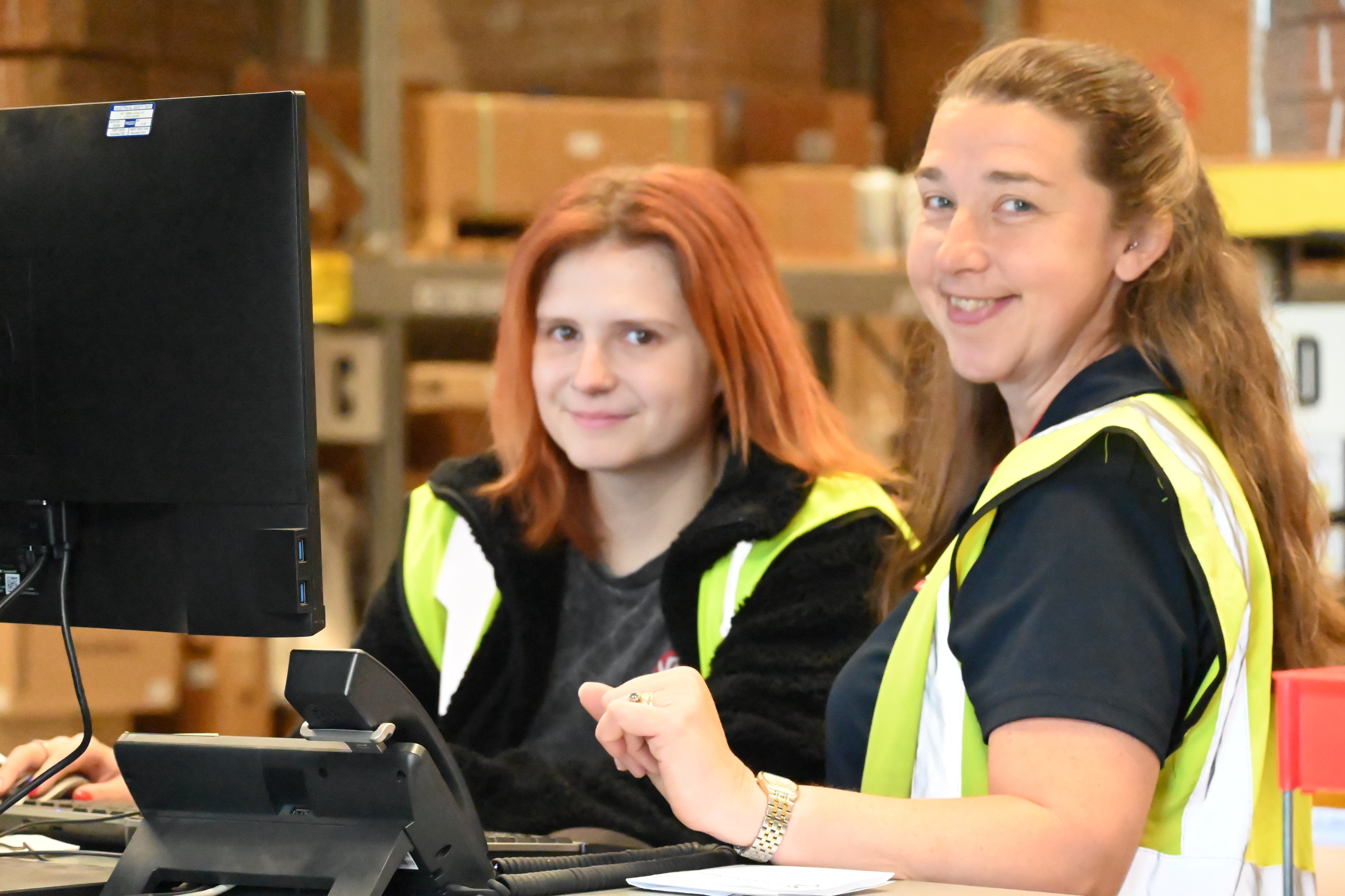 smiling warehouse workers in high vis
